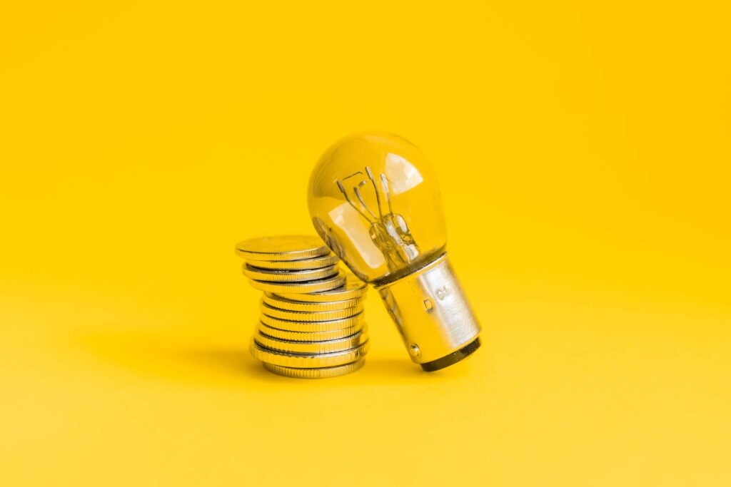 yellow light bulb and god coins on yellow background